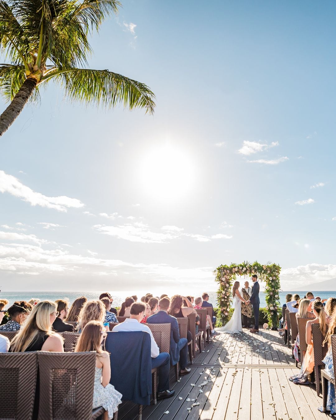 A wedding happening on the lawn by the beach at Merriman's Maui Restaurant